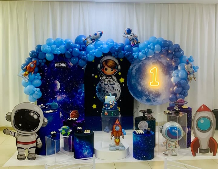Decoração temática espacial com balões e cenário de astronauta