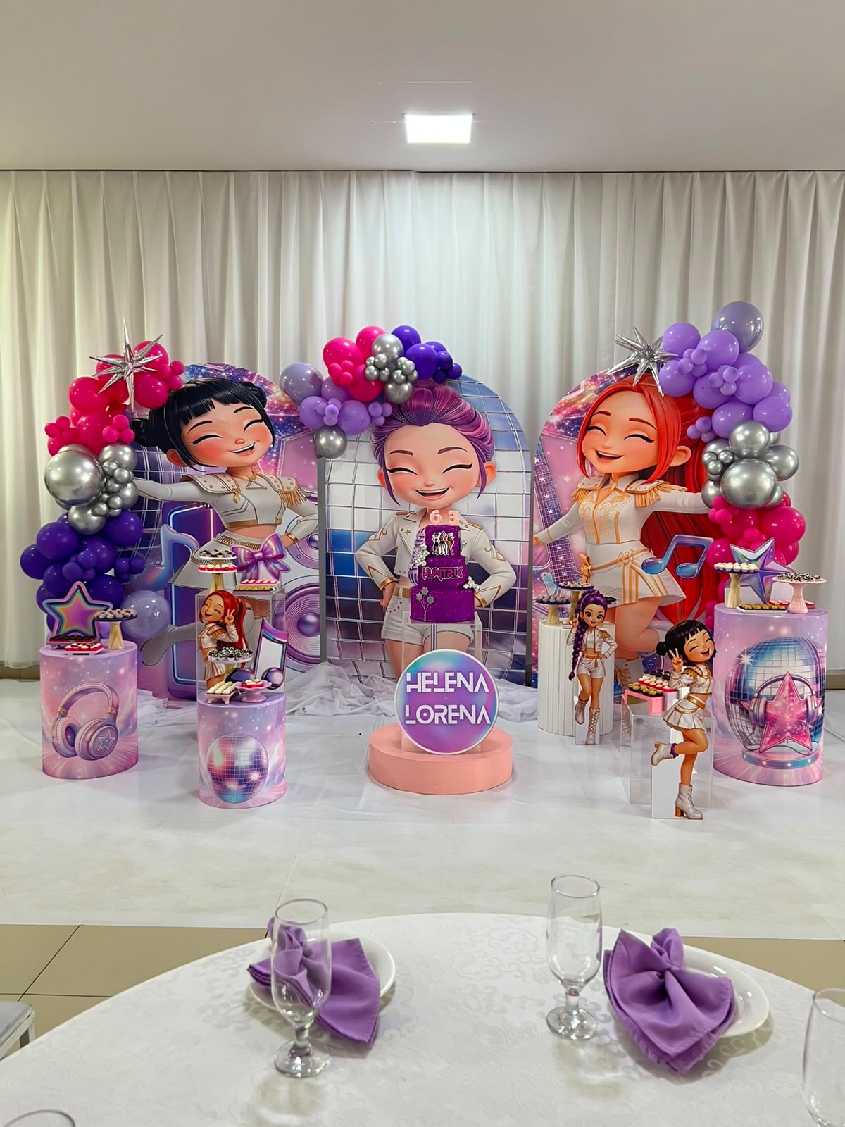 Decoração temática de show pop com arco de balões e painéis